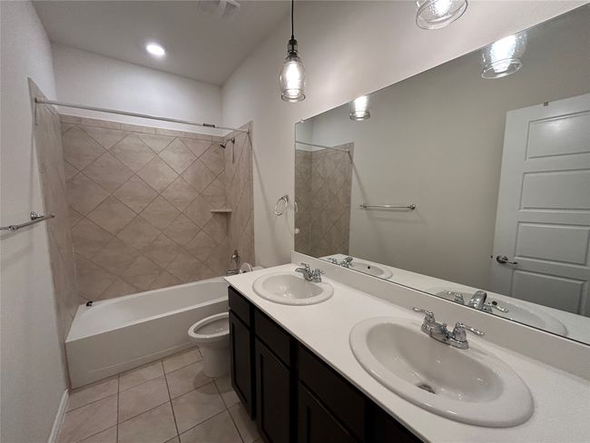 Full bath with tile patterned floors, shower / washtub combination, toilet, and double vanity | Image 18