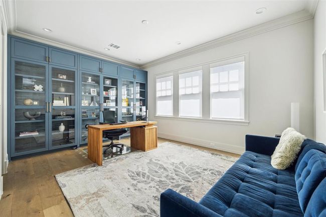 Versatile and filled with natural light, this oversized secondary bedroom with en-suite is designed for both comfort and functionality. Floor-to-ceiling built-ins add character and maximize storage, making it an ideal option for a spacious home office or creative workspace. | Image 24