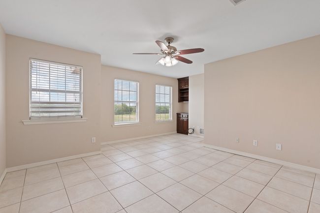 Upstairs bonus room with built in cabinets, tile flooring, ceiling fans and natural light. This was used for a large office space. Internet wired. | Image 27