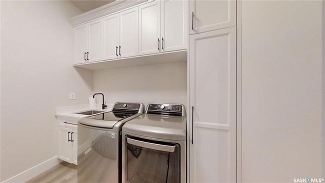 Laundry room with separate washer and dryer, cabinet space, and light wood-style floors | Image 17