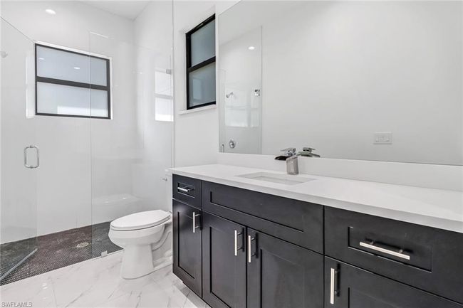 Bathroom featuring tile patterned floors, toilet, vanity, and an enclosed shower | Image 30