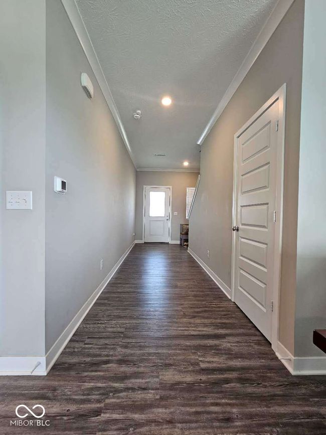 foyer featuring ornamental molding, wood finished floors, baseboards, a textured ceiling, and recessed lighting | Image 26