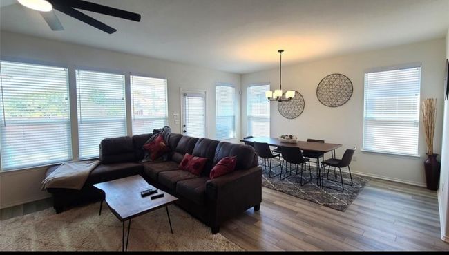 Living room with a chandelier, wood finished floors, and plenty of natural light | Image 15