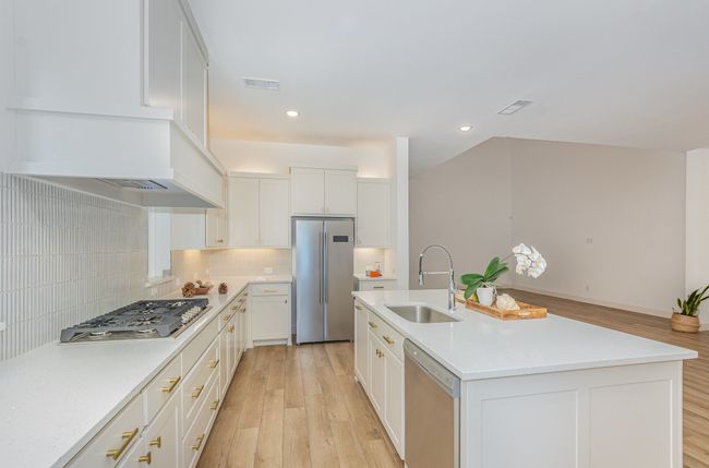 Kitchen featuring appliances with stainless steel finishes, light wood-style floors, backsplash, light countertops, and recessed lighting | Image 6