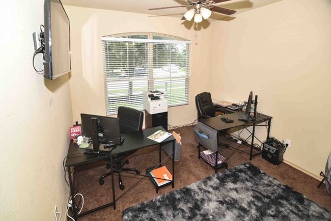 Carpeted office space with a ceiling fan | Image 12