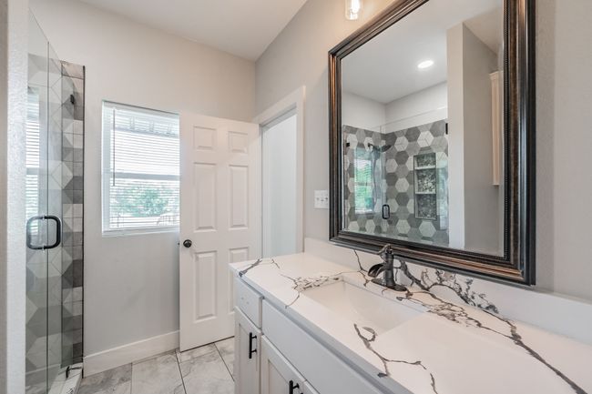 Bathroom featuring a shower stall, vanity, marble finish floors, and baseboards | Image 32