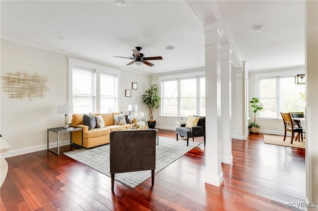 Living area with plenty of natural light, ornamental molding, ceiling fan, decorative columns, and dark wood-type flooring | Image 20