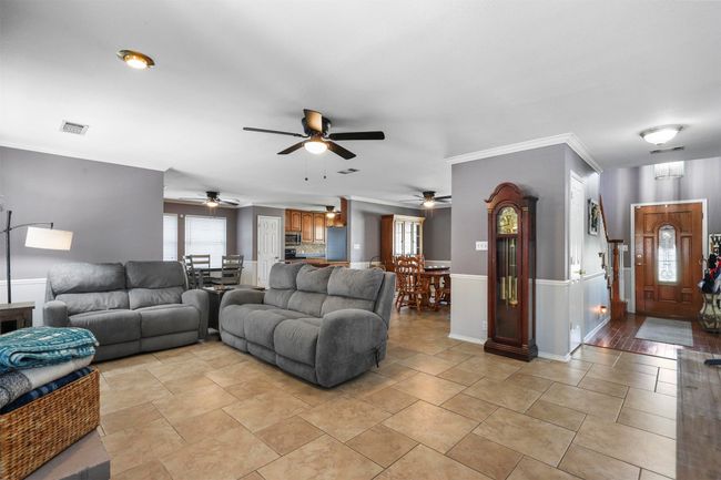 Living room featuring ornamental molding, ceiling fan, and light tile floors | Image 15