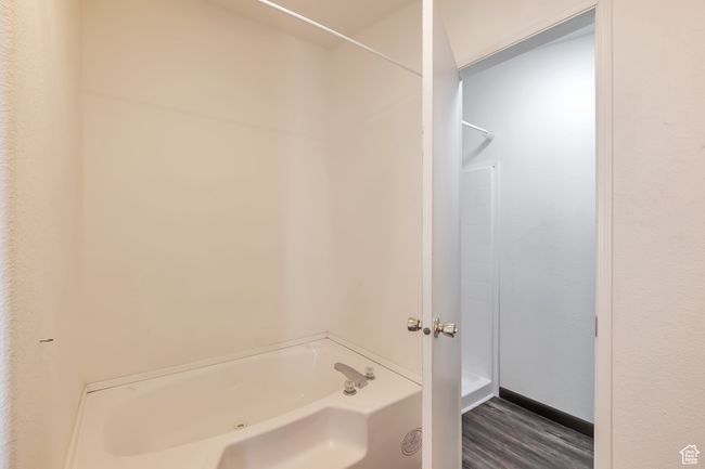 Bathroom with a bath and wood finished floors | Image 14
