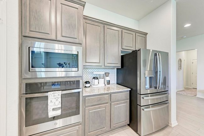 Stainless steel appliances complete this gourmet kitchen. Enjoy your custom coffee bar, conveniently tucked between the appliances on the granite counter. | Image 12