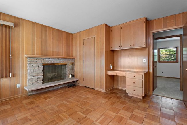 3rd bedroom on main level can serve as an office/den with built-in desk and wood burning fireplace with lake views! | Image 28