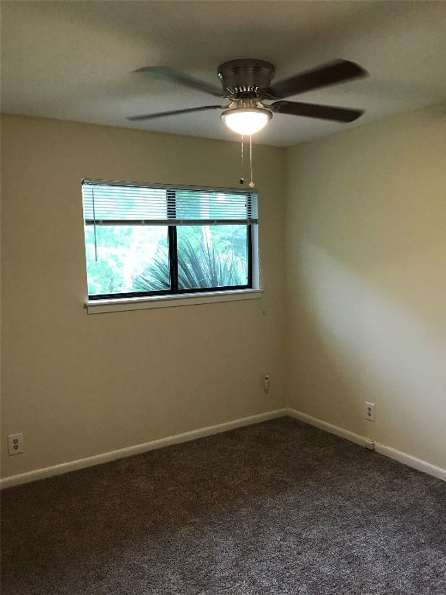 Spare room featuring baseboards, a ceiling fan, and dark colored carpet | Image 7