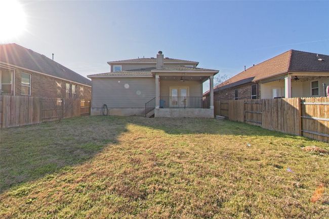 Rear view of house with a fenced backyard, a ceiling fan, and a chimney | Image 29