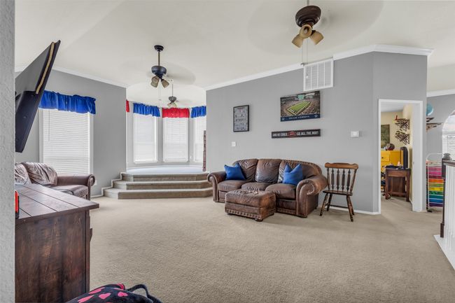 Living room with carpet flooring, ceiling fan, and ornamental molding | Image 23