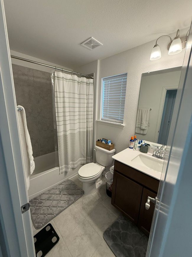 Full bathroom with vanity, shower / tub combo with curtain, a textured ceiling, and tile patterned floors | Image 13