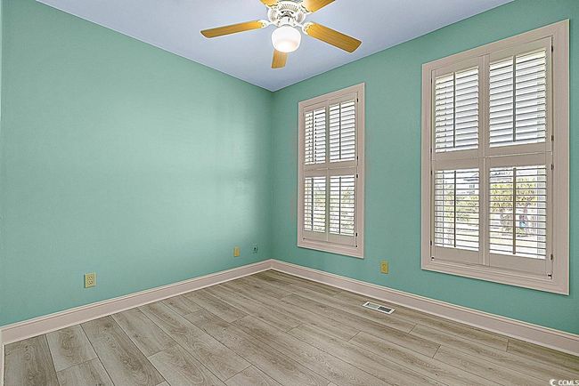 Unfurnished room with a ceiling fan, baseboards, visible vents, and wood finished floors | Image 18