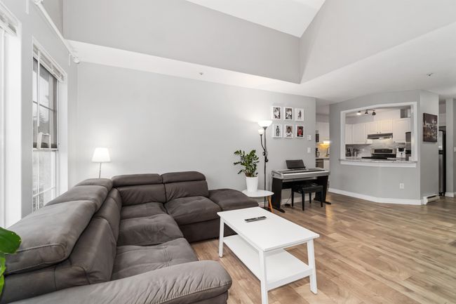 Living area with light wood-type flooring and a towering ceiling | Image 17