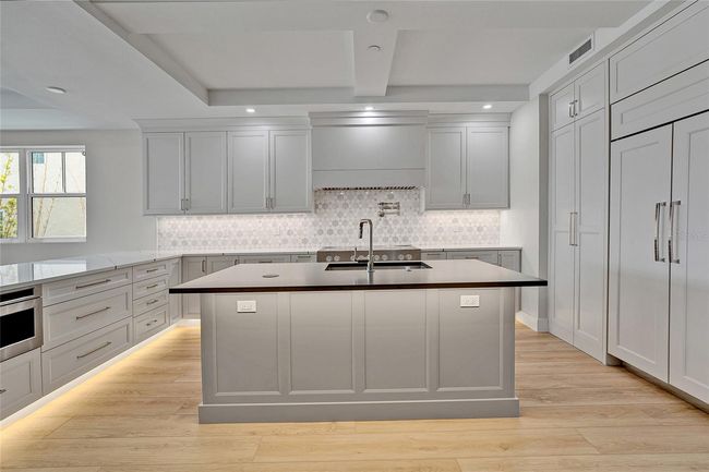 Spacious Kitchen Island Topped with Sleek Quartz Countertops | Image 10