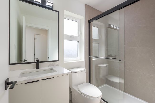 Bathroom with a shower stall, toilet, and vanity | Image 26