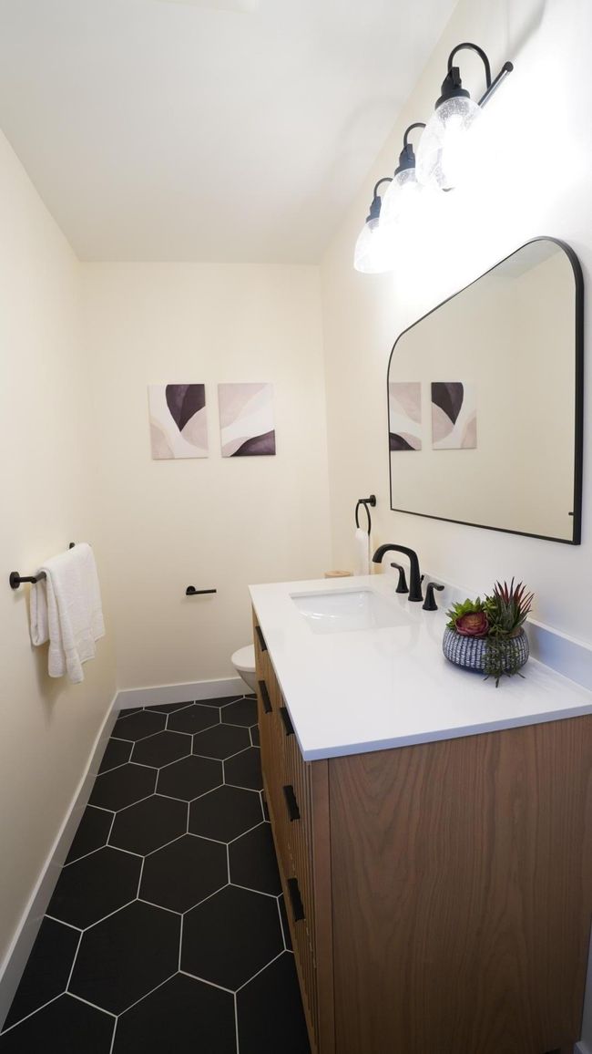The hall bath's brand new wood vanity is both modern and offers a lot of storage. | Image 21