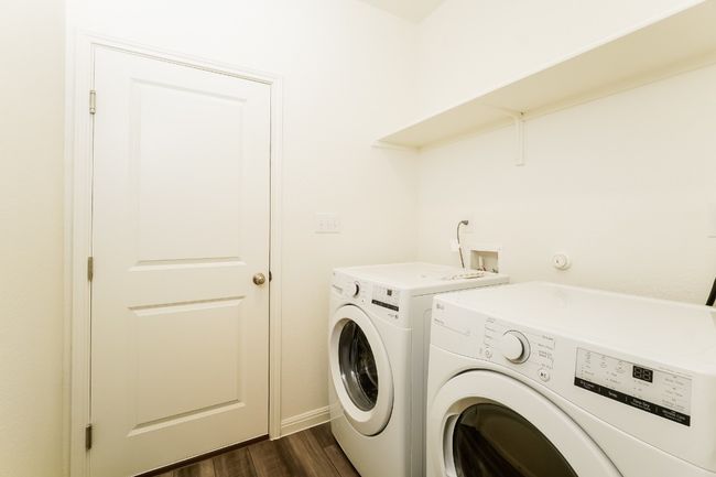 Laundry room with separate washer and dryer and dark wood-style flooring | Image 22