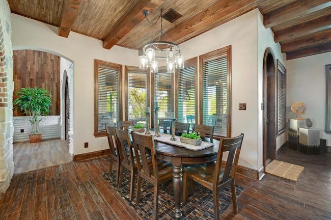 Dining space with dark wood-type flooring, wood ceiling, an inviting chandelier, and beam ceiling | Image 20