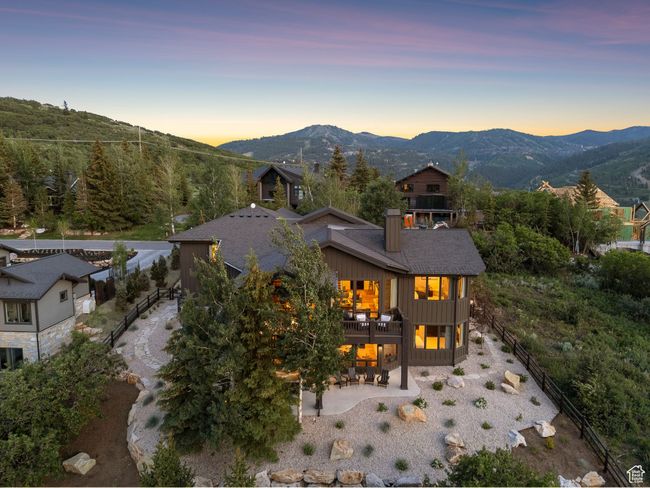 Back of property featuring a patio, a balcony, a mountain view, board and batten siding, and a chimney | Image 9