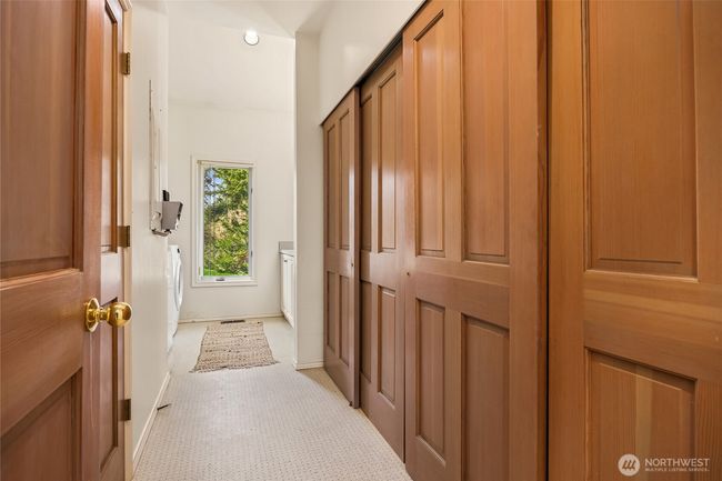 The laundry/utility room is on the main level (across from the kitchen) and features ample counter space for folding clothes and includes a utility sink. Additional storage closets along the right hand side. | Image 36