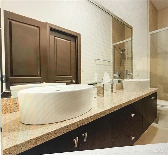 Full bath with a shower stall, double vanity, toilet, and tile patterned floors | Image 9