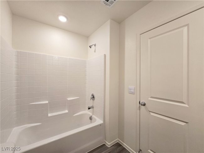 Bathroom featuring wood finished floors, shower / bath combination, baseboards, and recessed lighting | Image 27