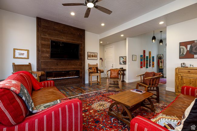 Living room with recessed lighting, baseboards, ceiling fan, a fireplace, and wood finished floors | Image 10