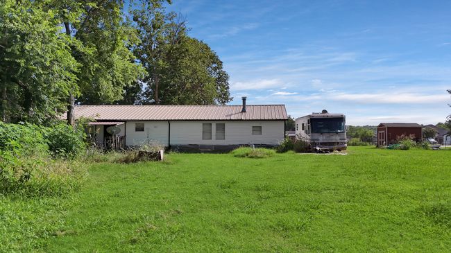Back of house featuring a yard and a metal roof | Image 12