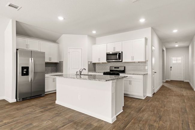 Full scope of Kitchen featuring stainless steel appliances, a sink, white cabinetry, backsplash, and recessed lighting | Image 5