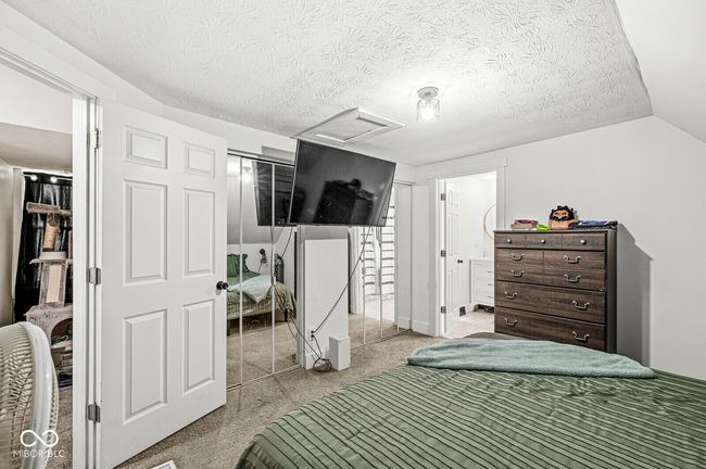 bedroom with attic access, light colored carpet, a textured ceiling, and a closet | Image 20