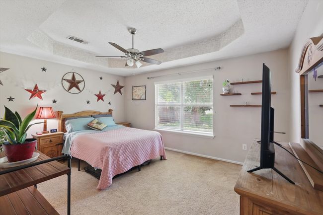 Bedroom featuring visible vents, a tray ceiling, and a textured ceiling | Image 20
