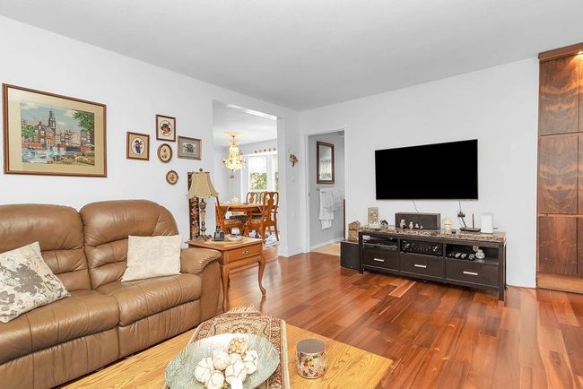 Living area with an inviting chandelier and dark wood finished floors | Image 14