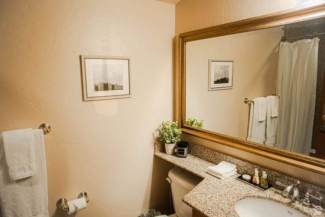 Full bathroom with toilet, a textured wall, and vanity | Image 26