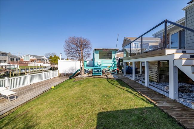 View of yard with a residential view, a deck, fence, and a playground | Image 28