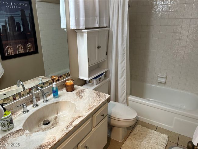 Full bathroom featuring vanity, shower / tub combo with curtain, and tile patterned flooring | Image 34