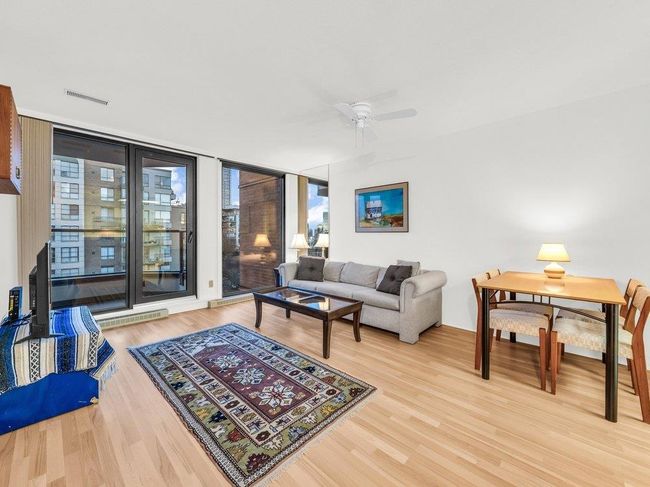 Living area featuring ceiling fan, floor to ceiling windows, visible vents, and light wood-style floors | Image 5
