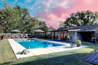 Pool at dusk featuring a patio and a lawn | Image 2