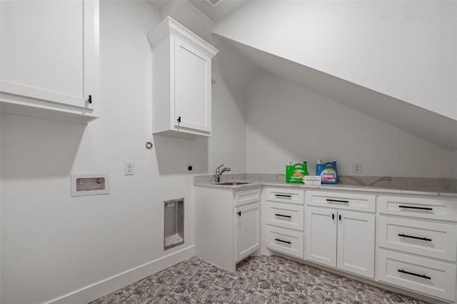 Spacious laundry room with ample storage, sleek countertops, and a convenient wash station. | Image 30