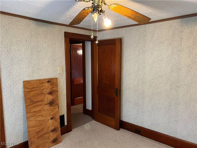 Unfurnished bedroom featuring ornamental molding, a textured ceiling, and ceiling fan | Image 9
