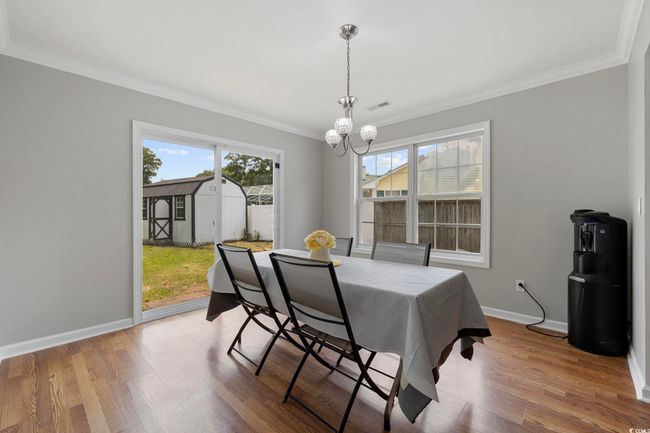 Dining area featuring ornamental molding, a chandelier, wood finished floors, and baseboards | Image 31