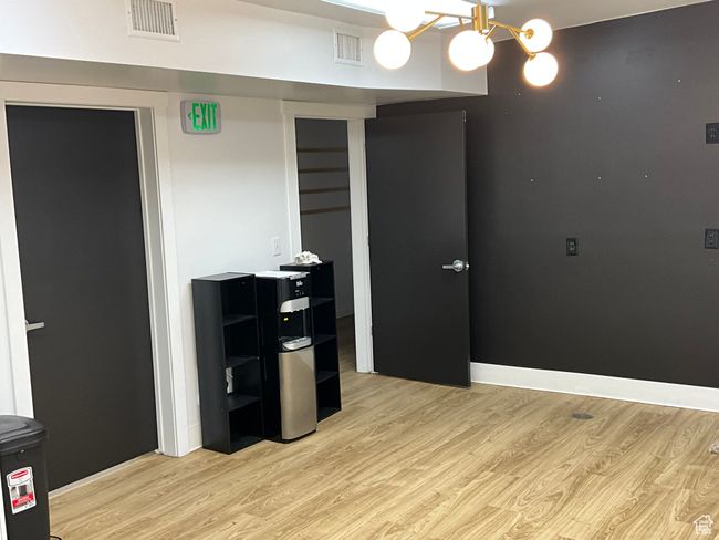 Unfurnished room with visible vents, a notable chandelier, and light wood-style floors | Image 17
