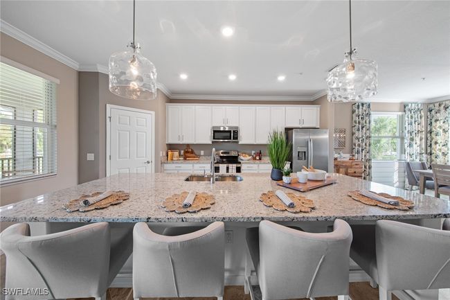 Kitchen with a sink, appliances with stainless steel finishes, crown molding, white cabinetry, and a spacious island | Image 14