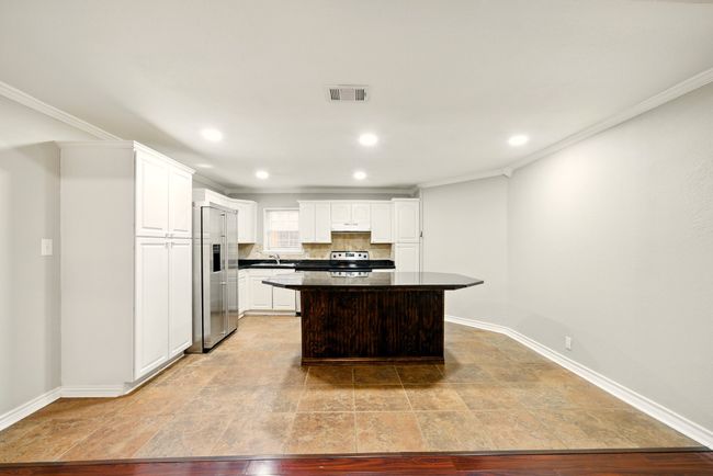 From the living room, enjoy a clear view into the open kitchen featuring a spacious island—ideal for casual meals, conversation, and hosting guests. | Image 8