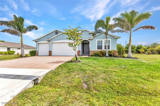 Single story home with an attached garage, stucco siding, decorative driveway, and a front lawn | Image 45