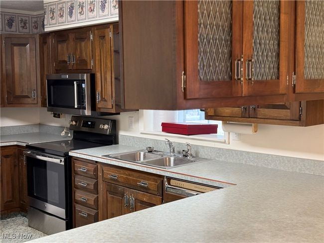 Kitchen featuring light countertops, appliances with stainless steel finishes, and a sink | Image 14