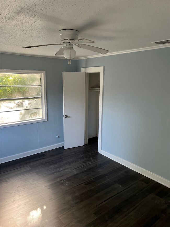 Unfurnished bedroom featuring baseboards and dark wood finished floors | Image 6